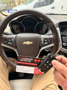Automotive locksmith technician programming a new Chevrolet flip key inside the vehicle for A-I Locksmith And Security.