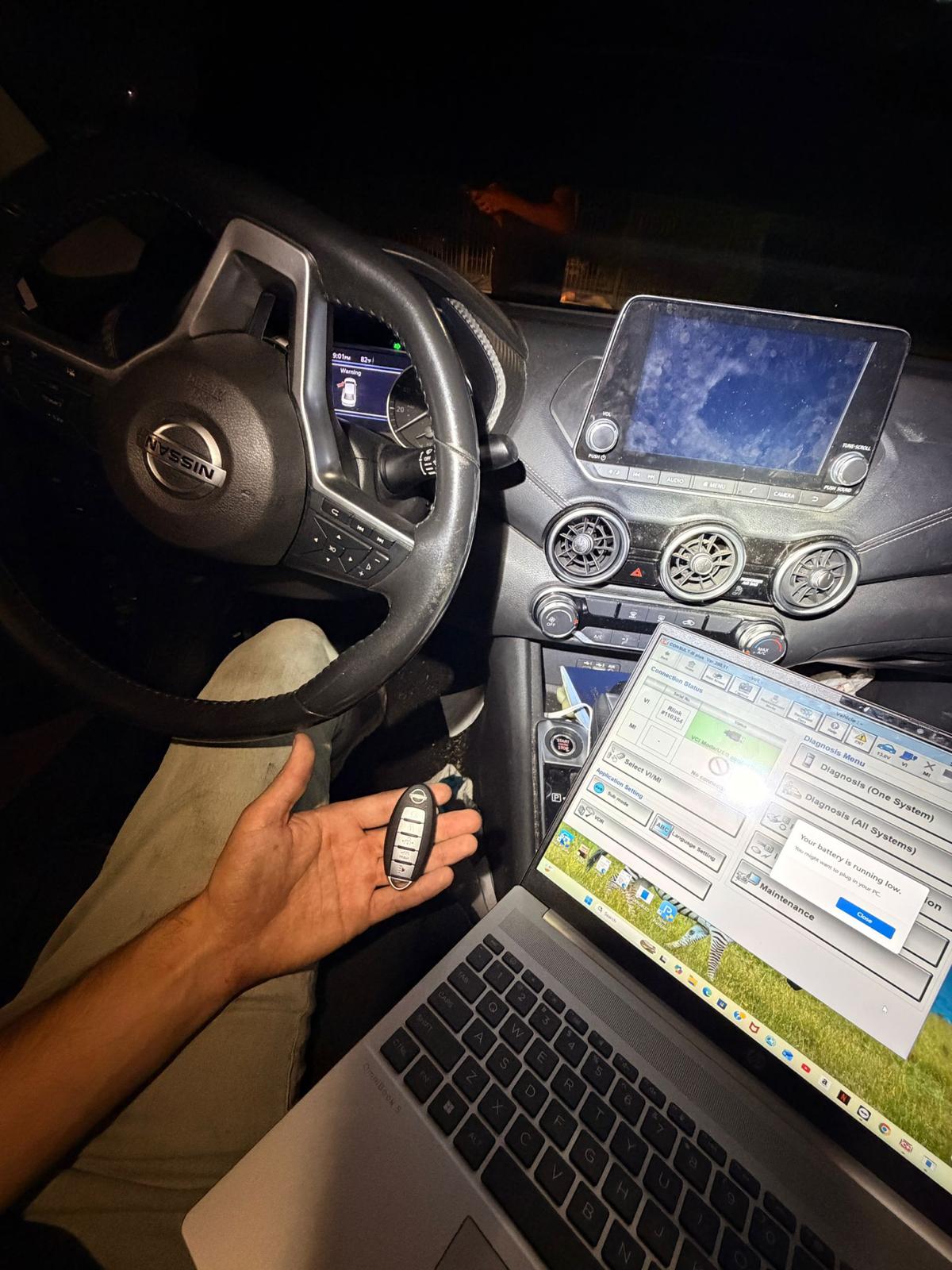 Nissan key fob and programming laptop during an evening mobile visit